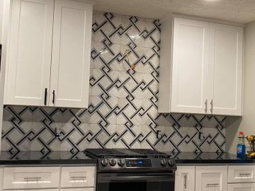 kitchen wall with 2 cabinets, stovestop, and countertops visible